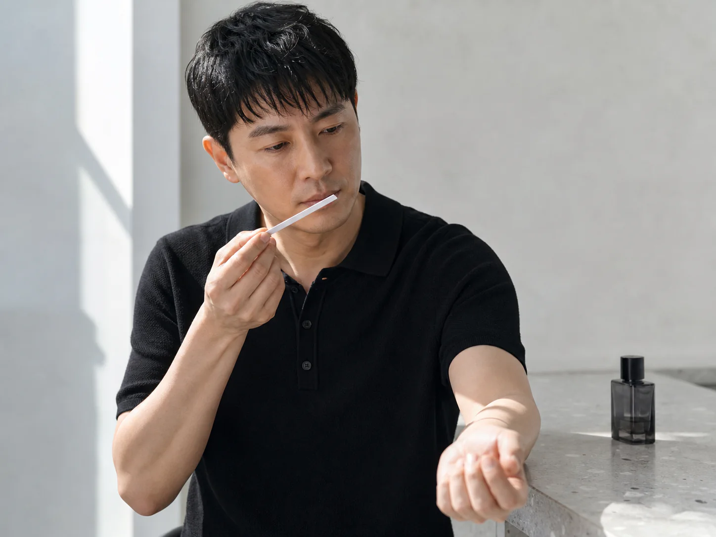 香り紙と手首で香調を比べる男性