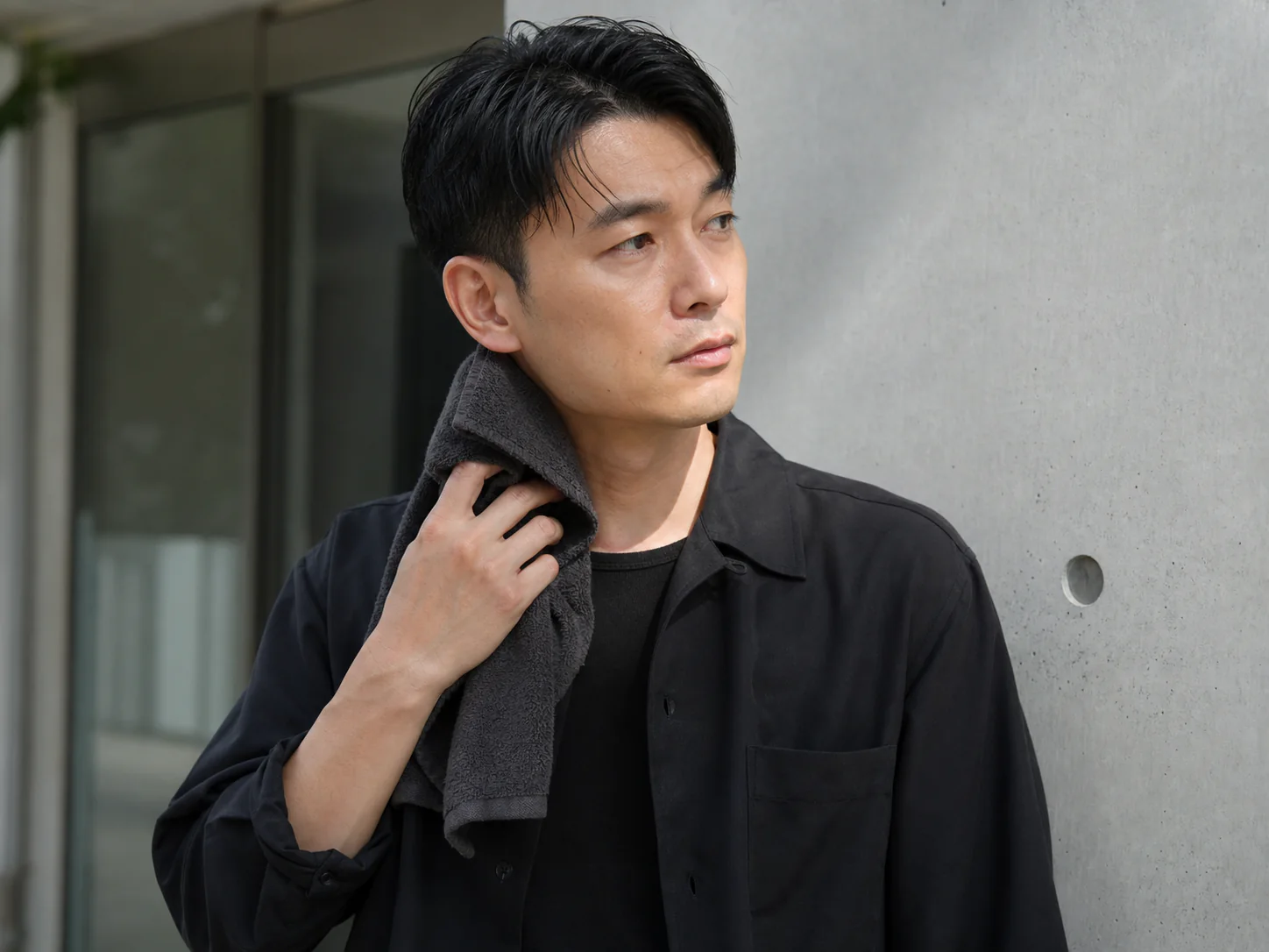通勤後に首元の汗を整える男性