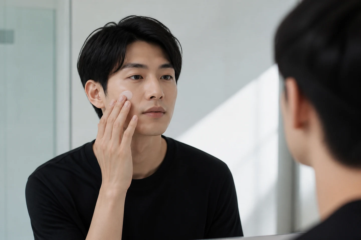 朝の鏡前で肌を整える男性