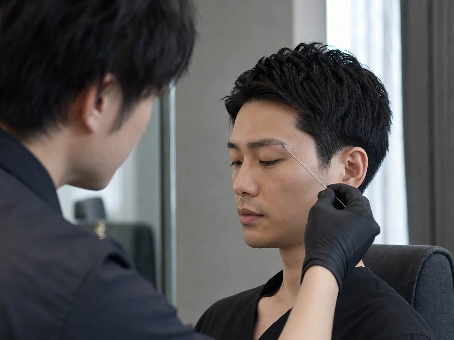 眉スタイリストが骨格に沿って形を確認する様子